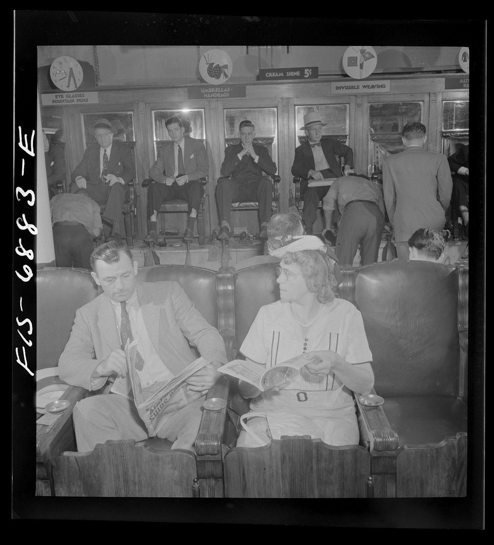 New York, New York. Shoeshine parlor on East Forty-Second Street. Customers in the foreground are waiting while their shoes…