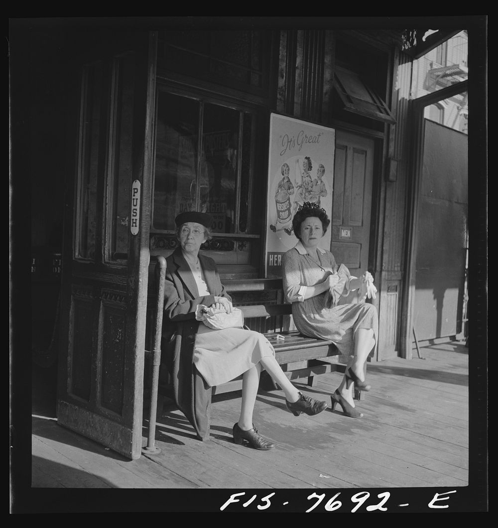 New York, New York. Women waiting for an elevated train at 67th Street and Third Avenue station, 8:30 a.m.. Sourced from the…