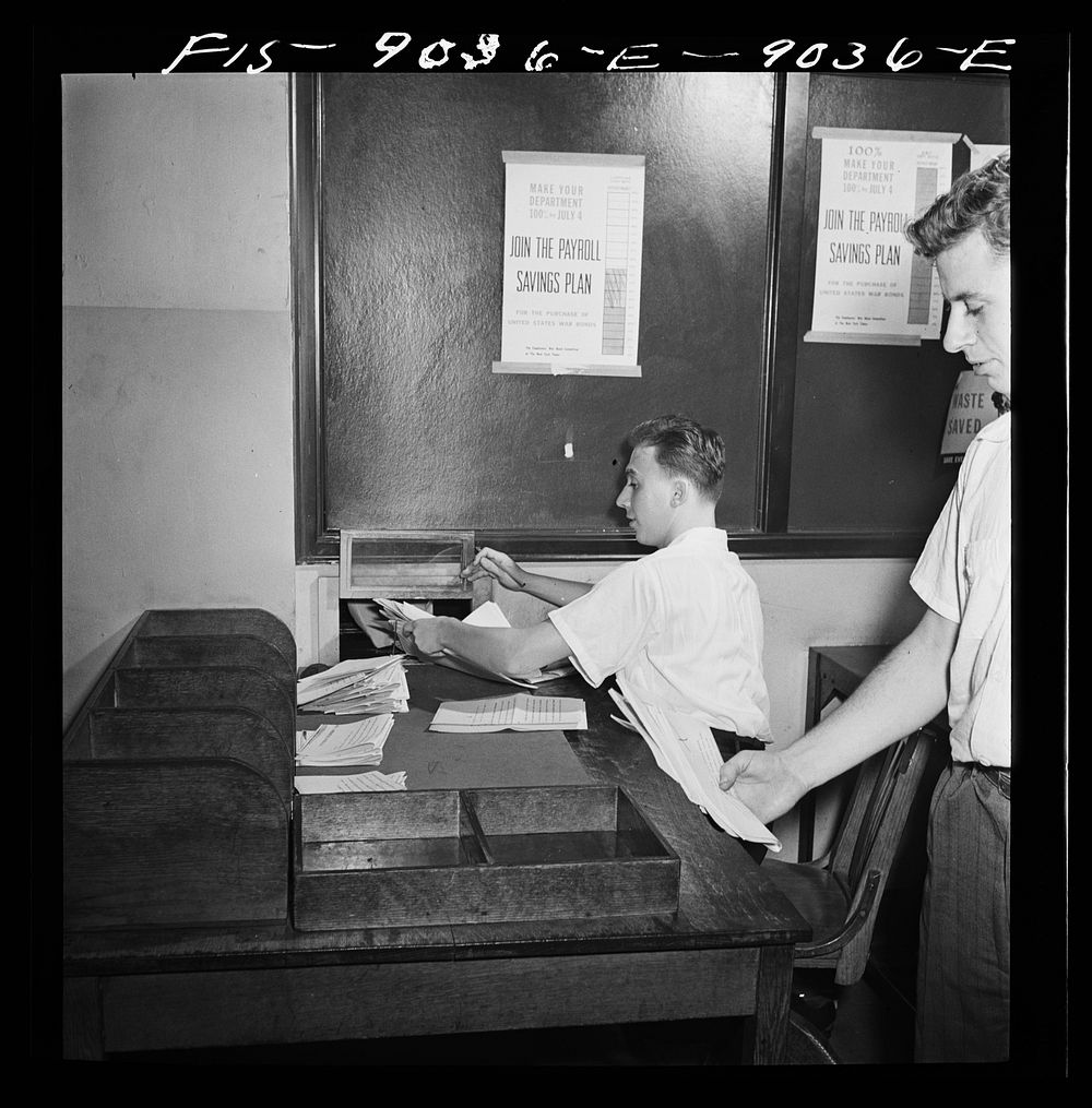 New York, New York. News room of the New York Times newspaper. Copy boy receives mimeographed dispatches from telegraph room…