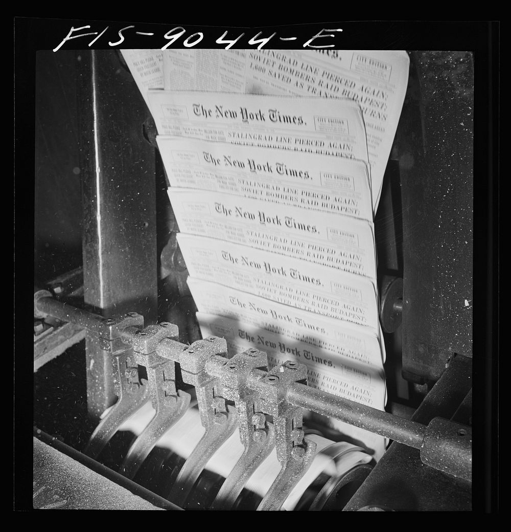 New York, New York. Pressroom of the New York Times department. Finished papers come out of cutting and folding machine on…