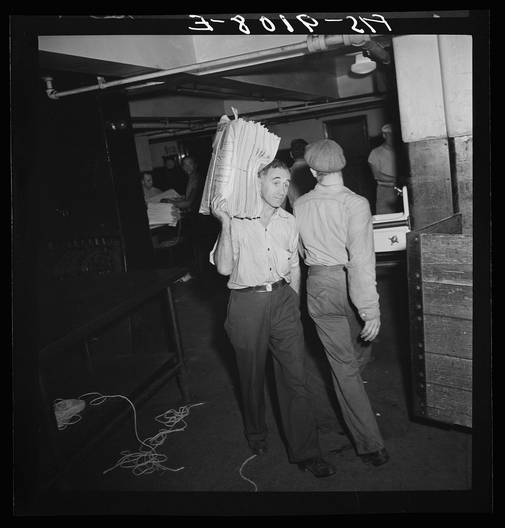New York, New York. Mailroom of the New York Times newspaper. Bundles of papers are carried to trucks for distribution.…