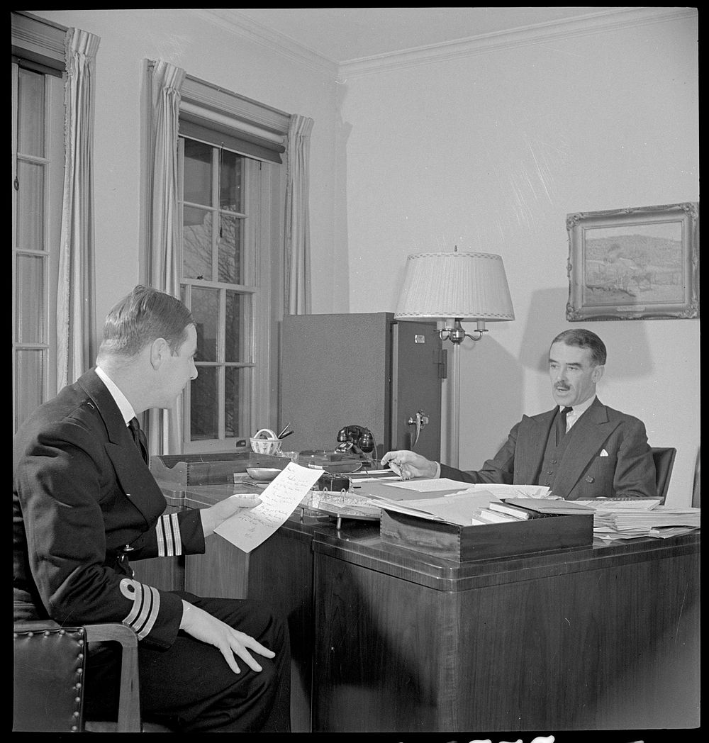 Washington, D.C. The Australian Legation. Mr Casey, minister from Australia, conferring with the naval attache. Sourced from…