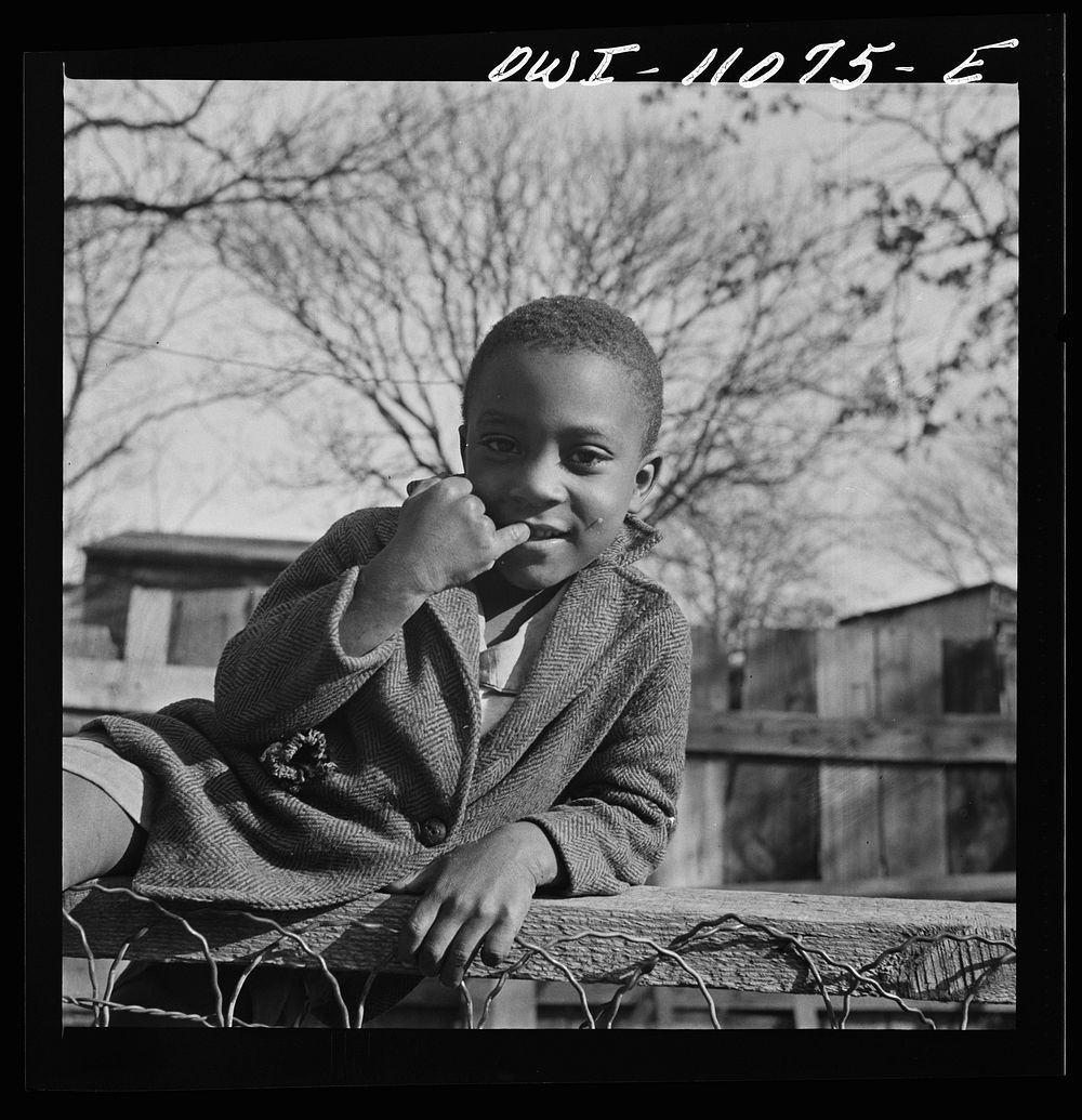 Washington (southwest section), D.C. Boy playing on a fence. Sourced from the Library of Congress.