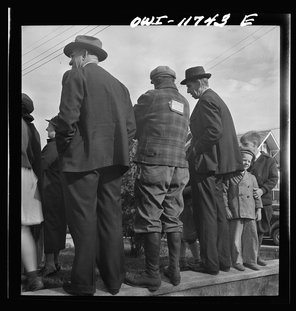 Lititz, Pennsylvania. Bidders at a public sale. Center one has hunting license on his back. Sourced from the Library of…