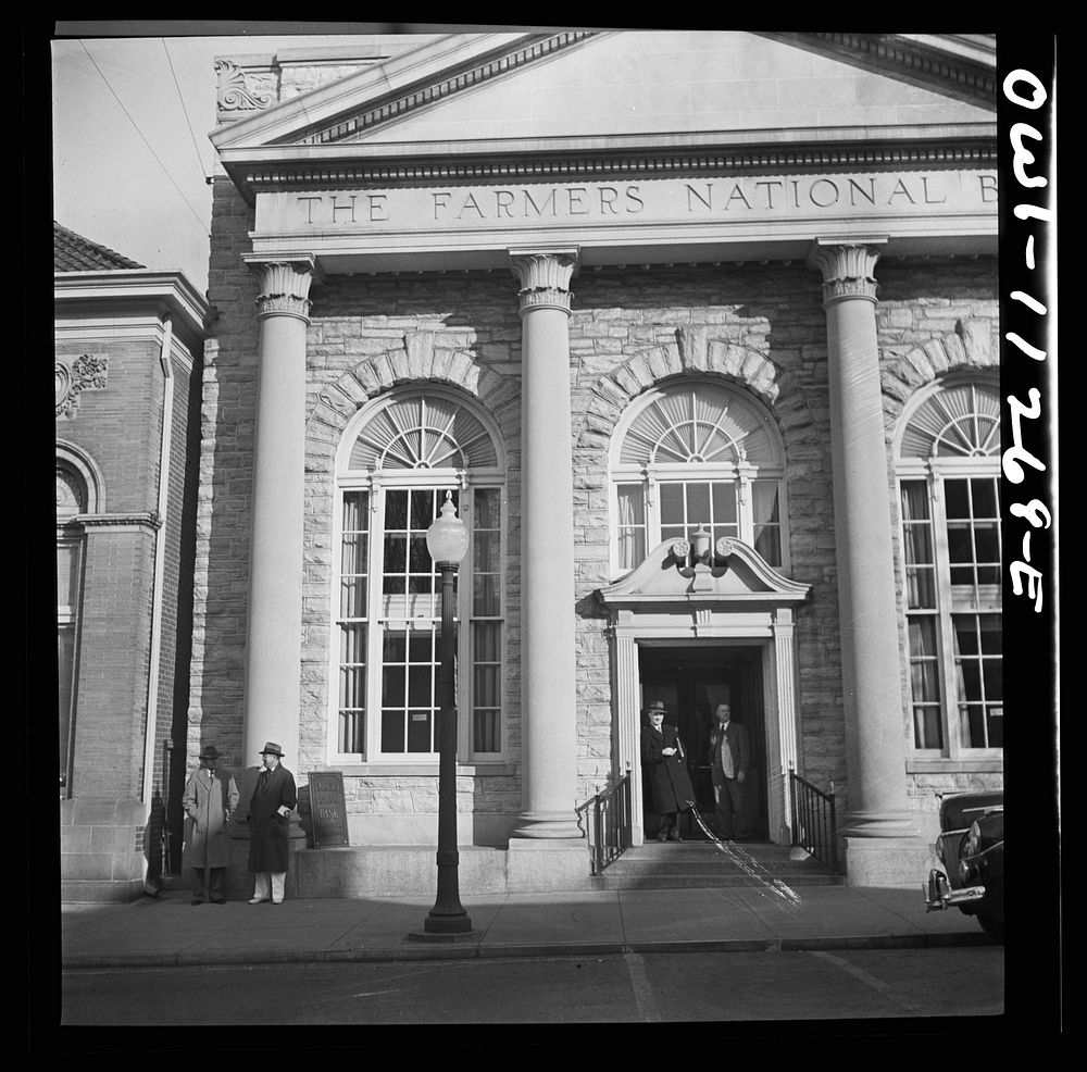 Lititz, Pennsylvania. Air raid wardens on duty and passersby taking shelter in the bank doorway during an raid drill.…