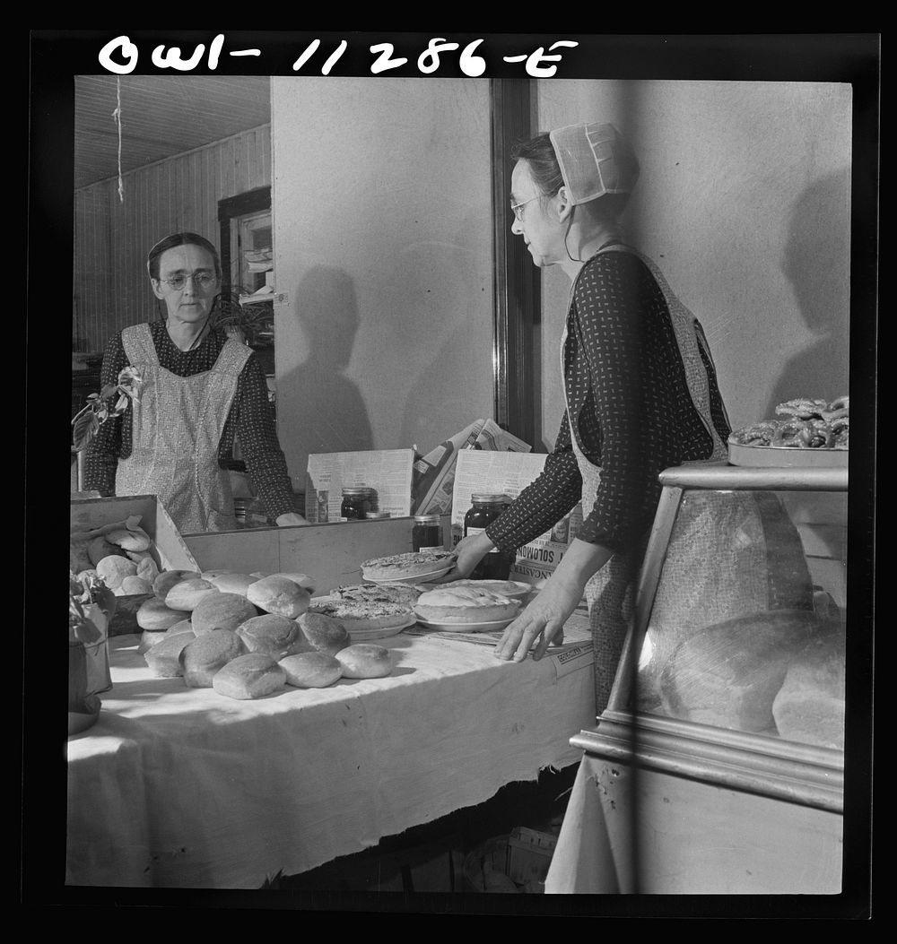 Lititz, Pennsylvania. Mennonite woman arranging baked goods at the farmers' market. Sourced from the Library of Congress.