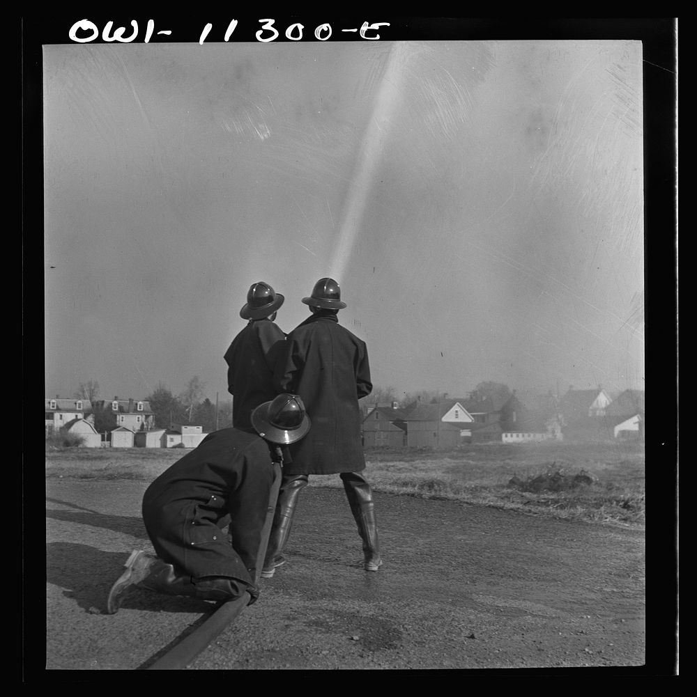 Lititz, Pennsylvania. Volunteer firemen practicing in a vacant lot during an air raid drill. Sourced from the Library of…