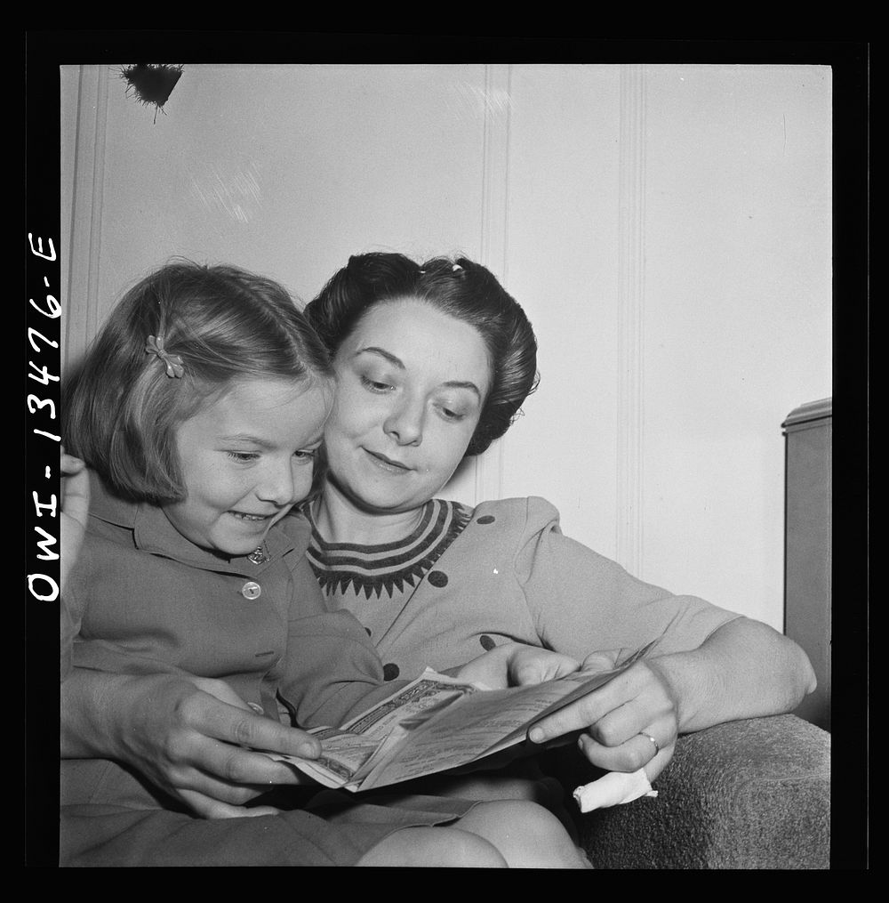 New York, New York. Martinetti's daughter and granddaughter examining a bond the child received for Christmas. Sourced from…
