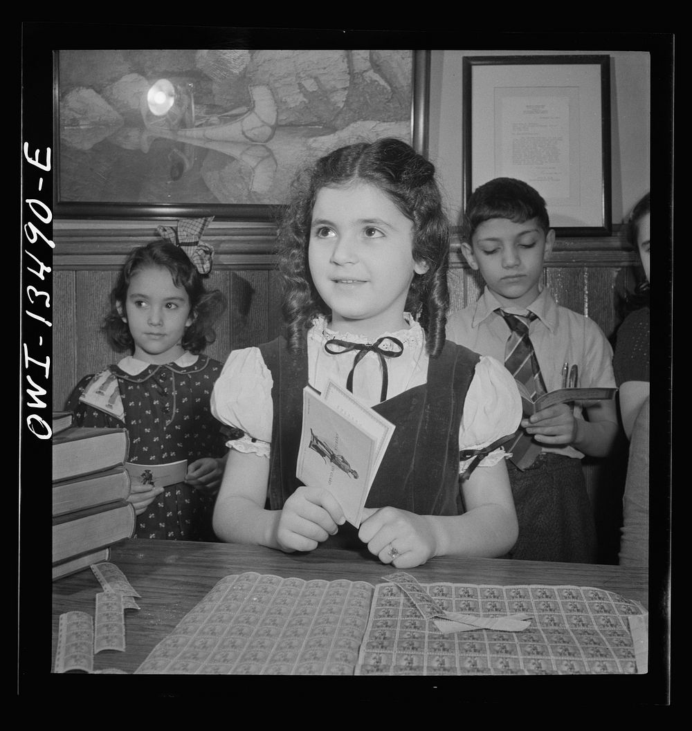 New York, New York. Children waiting in line to buy defense stamps at public school from mothers who volunteer to guard…