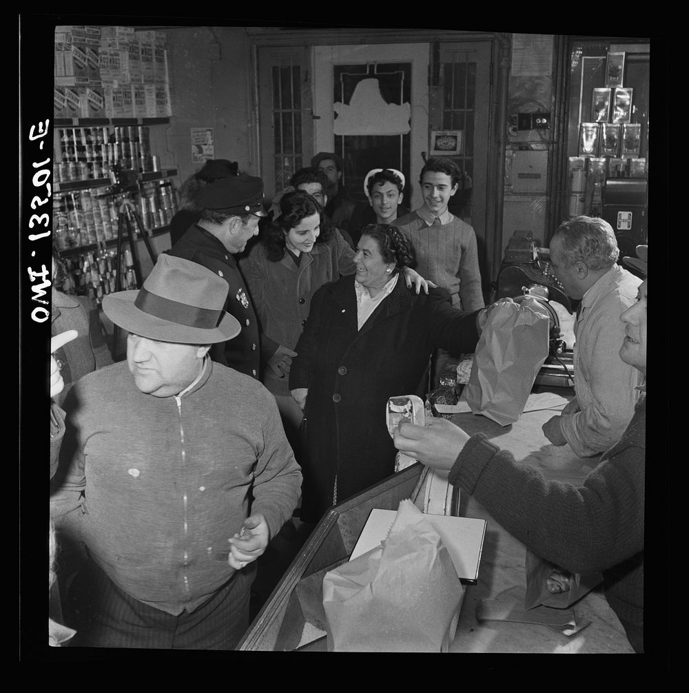New York, New York. Italian-American policeman chatting with customers in a grocery store on Mulberry Street. Sourced from…