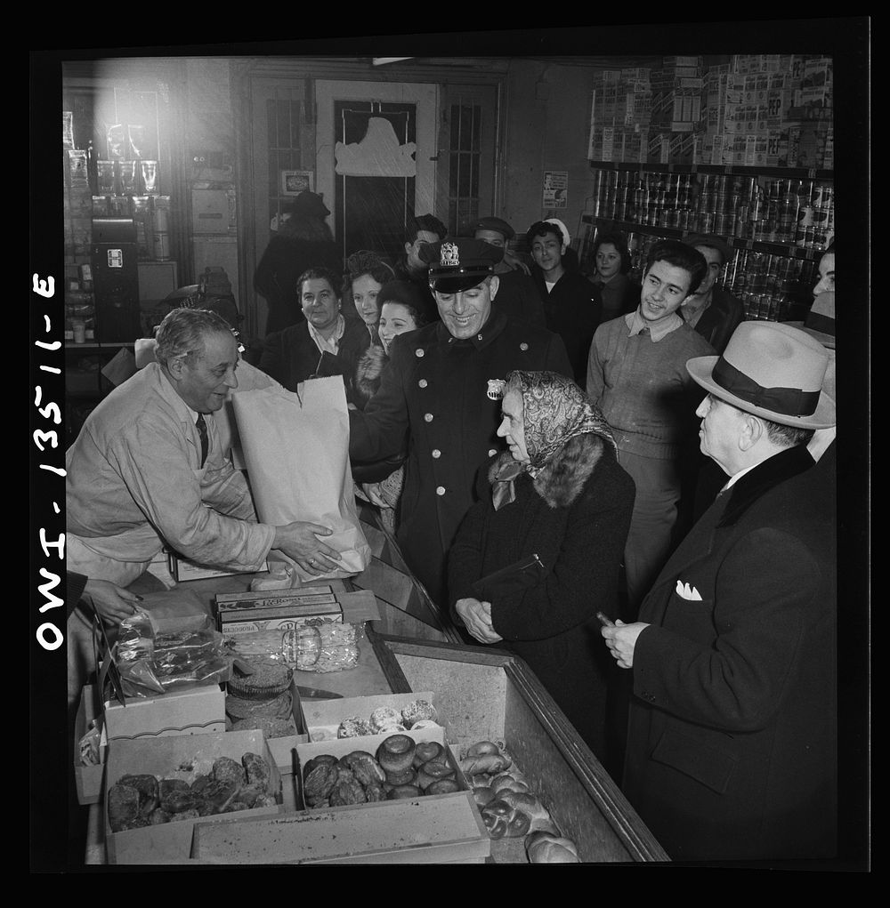 New York, New York. Italian-American policeman chatting with customers in a grocery store on Mulberry Street. Sourced from…