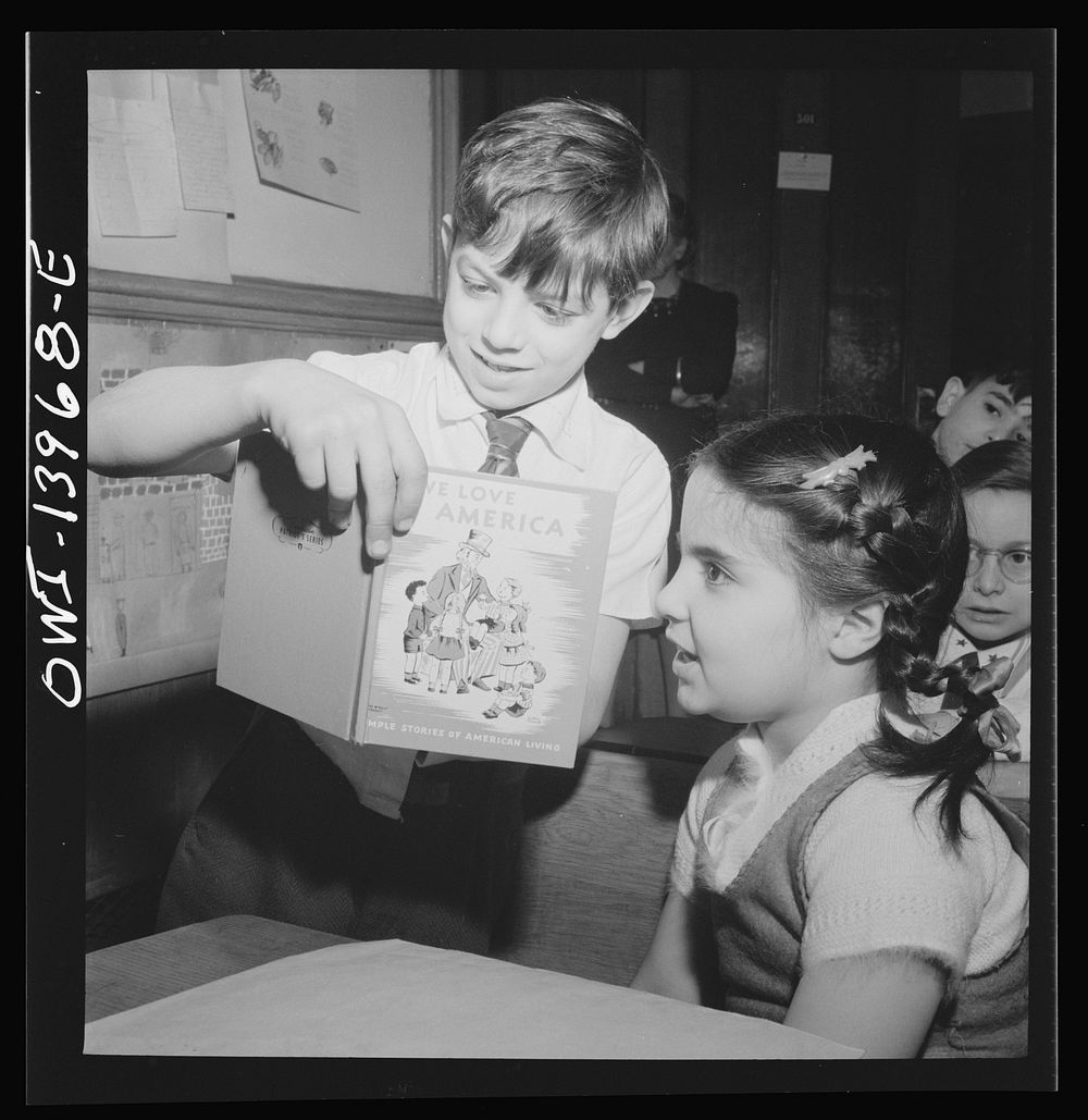 New York, New York. This boy has brought a book to Public School Eight which he is showing to fellow pupils during class…