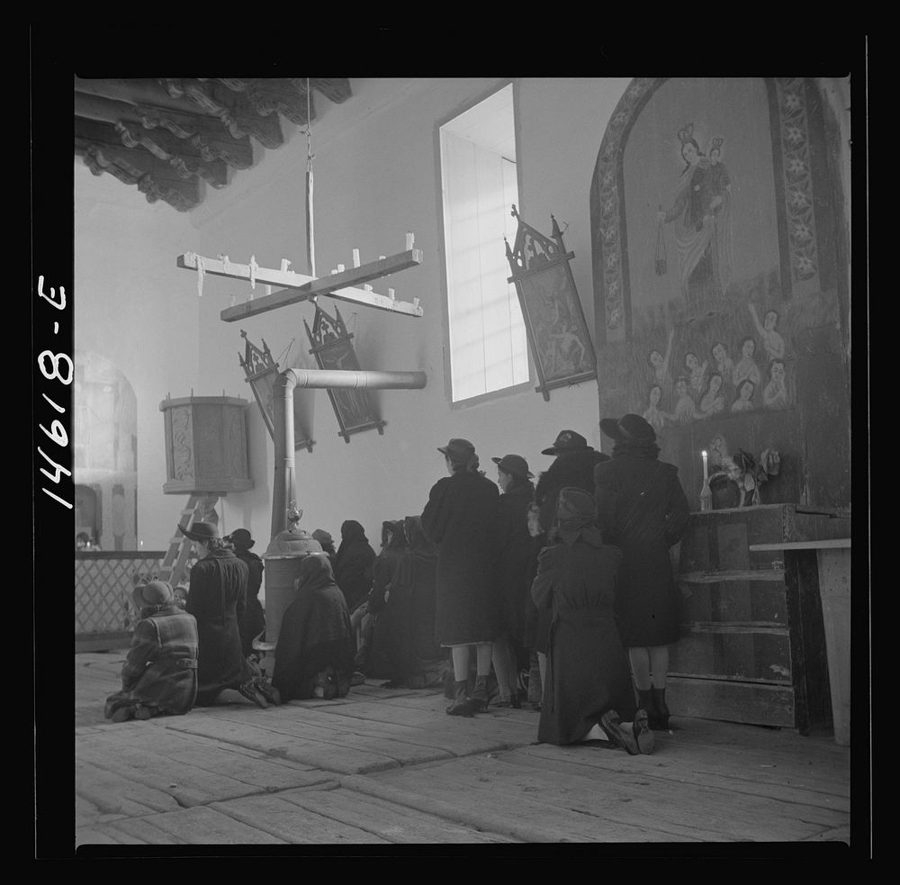 Trampas, New Mexico. Service at the mission church. The painting on the retablo represents Nuestra Senora del Carmel.…