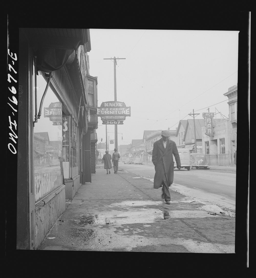 [Untitled photo, possibly related to: Detroit, Michigan. Back view of a  dressed in a zoot suit, walking in the business…