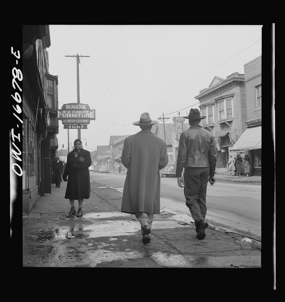 Detroit, Michigan. Back view of a  dressed in a zoot suit, walking in the business district. Sourced from the Library of…