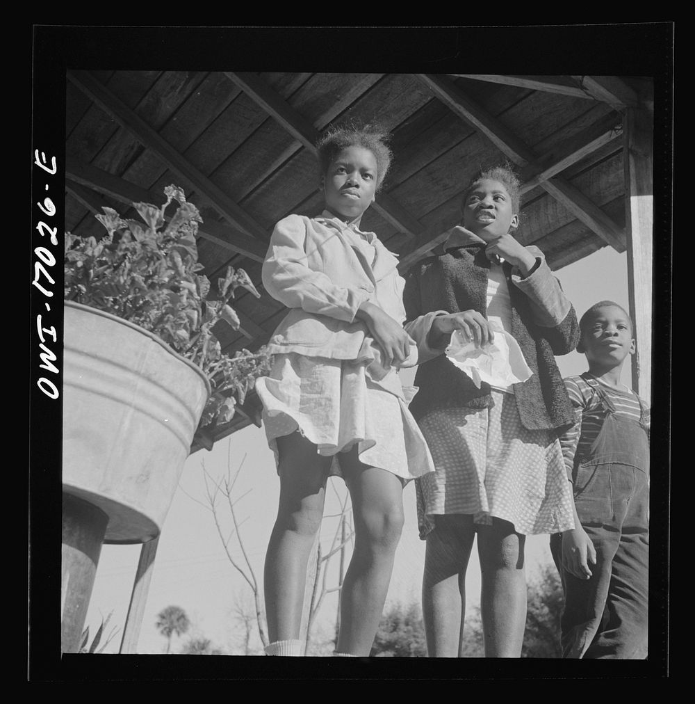 Daytona Beach, Florida. Two sisters with their brother on the front porch of the family home. Sourced from the Library of…