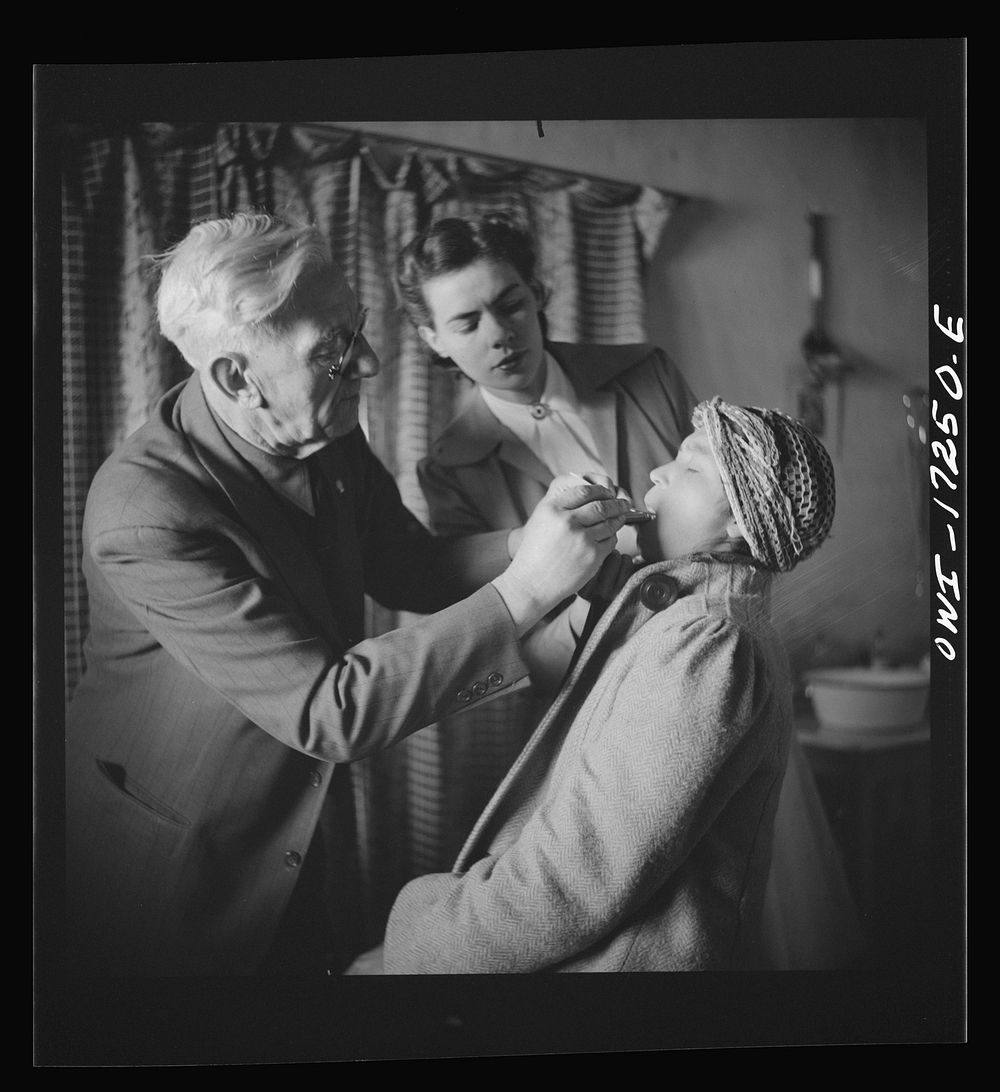 [Untitled photo, possibly related to: Penasco, New Mexico. Doctor Onstine, medical doctor, making an examination in the…