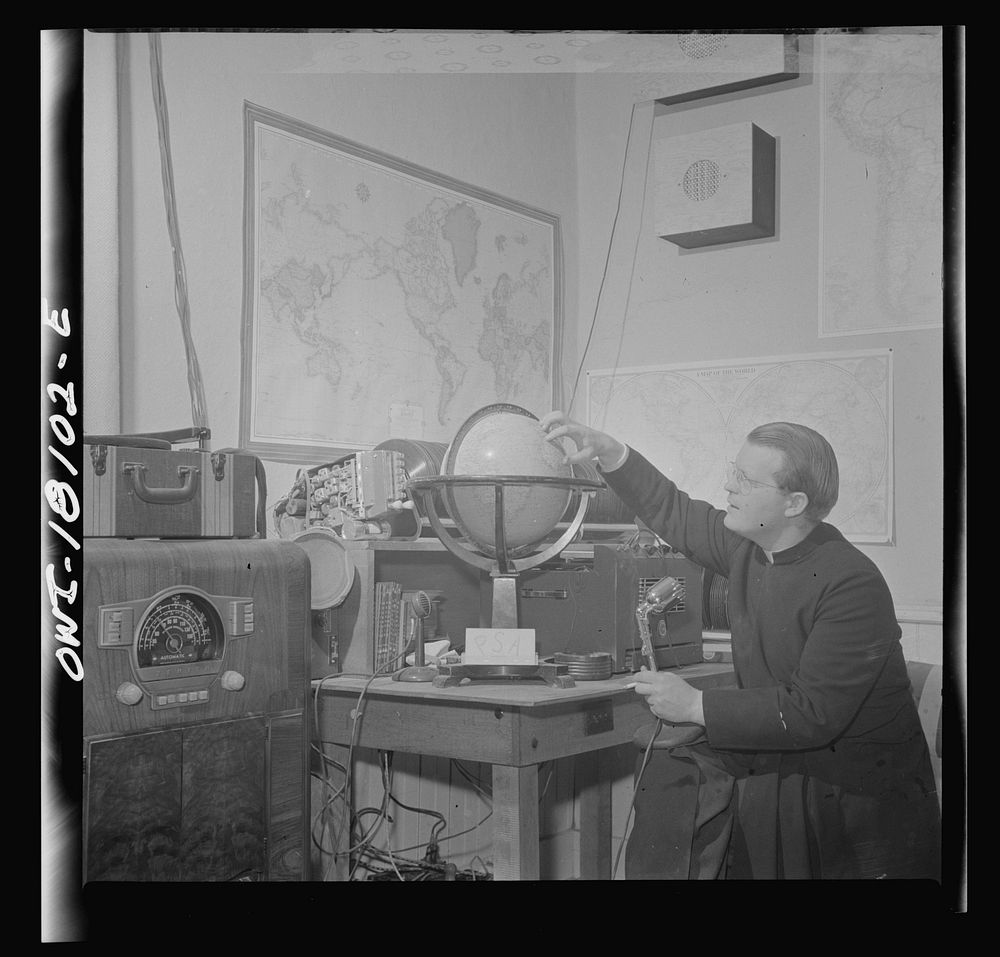 Questa, New Mexico. Father Smith broadcasting a news release in Spanish from his parish house broadcasting station. Sourced…