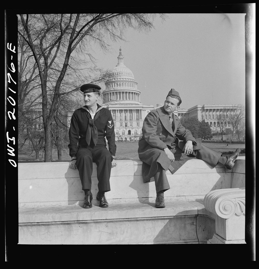 Washington, D.C. Soldier and a sailor on the steps of a monument in front of the Capitol on a Sunday. Sourced from the…