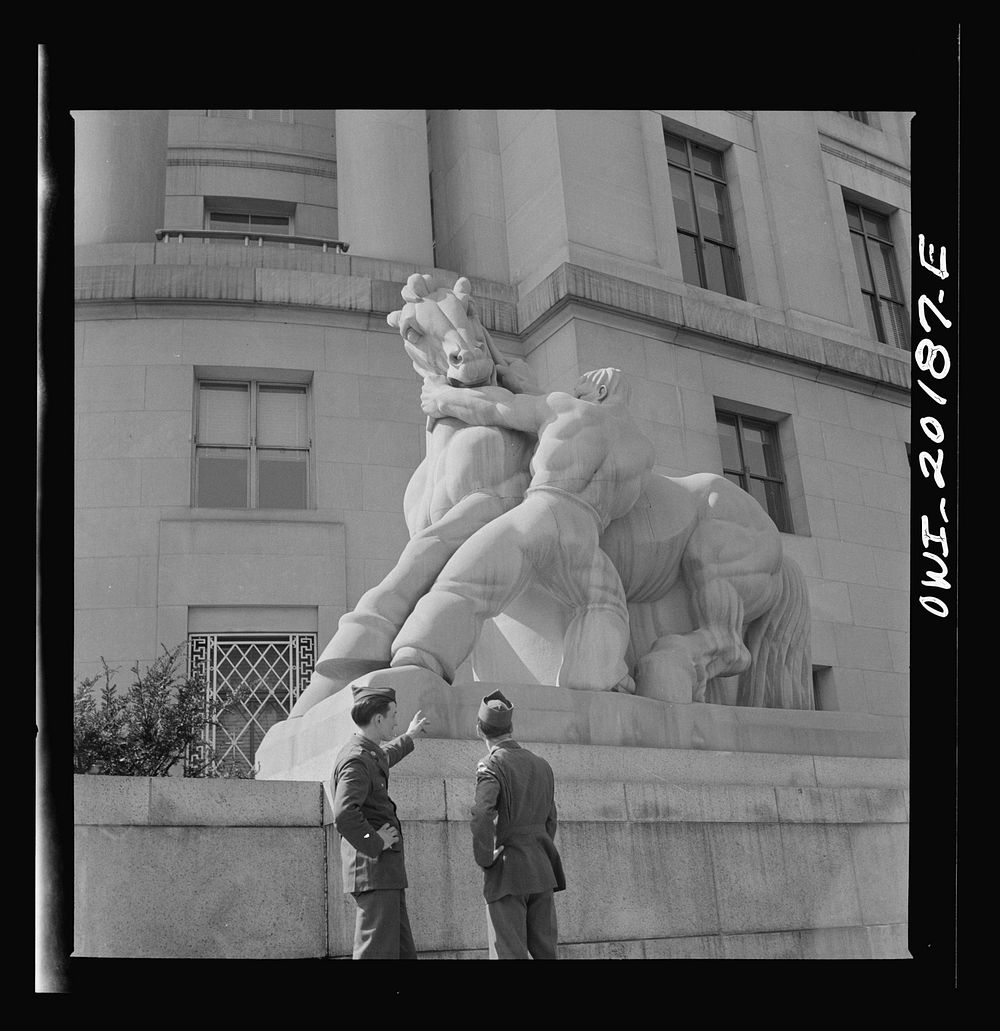 Washington, D.C. Soldiers looking at the statue in front of the Federal Trade Commission building. Sourced from the Library…
