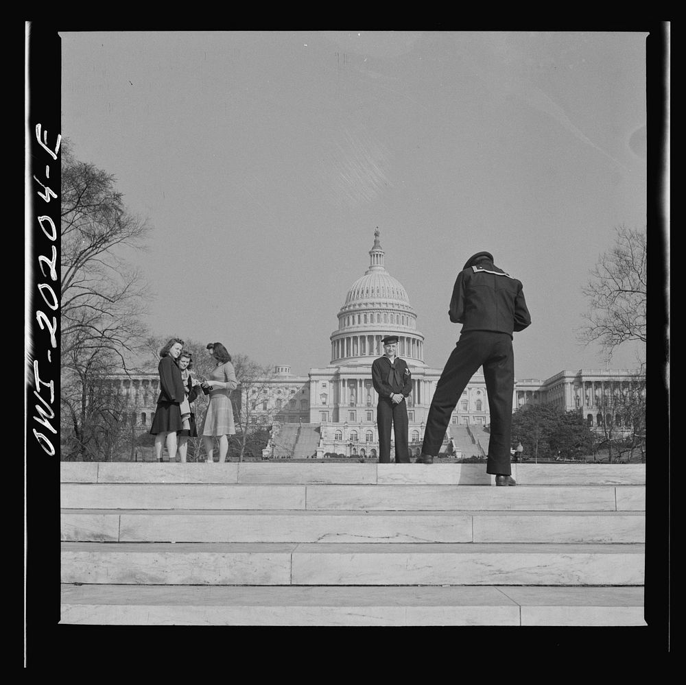 Washington, D.C. Sailor taking pictures on the steps of the National Gallery of Art on a Sunday afternoon. The Capitol is in…