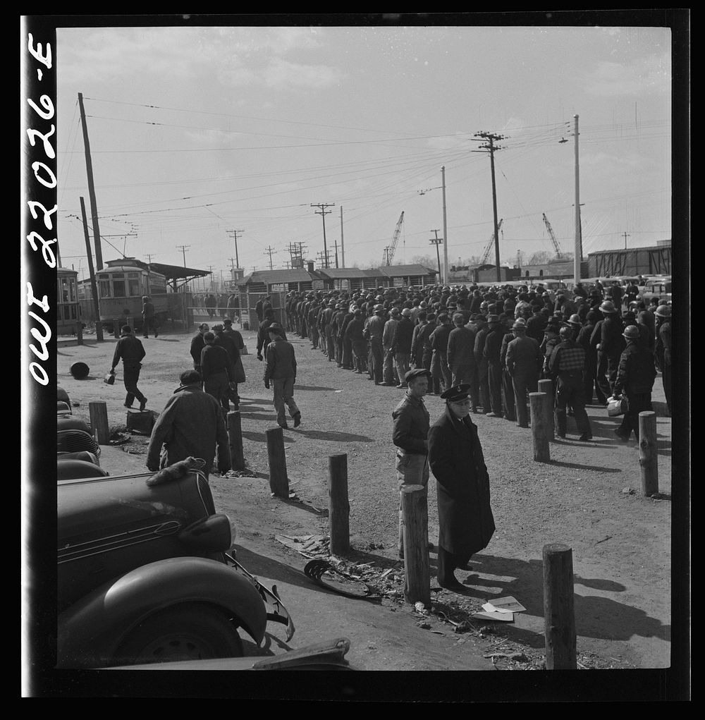 Baltimore, Maryland. Workmen of the second shift of the Bethlehem Fairfield shipyard lining up at the gate waiting to get on…