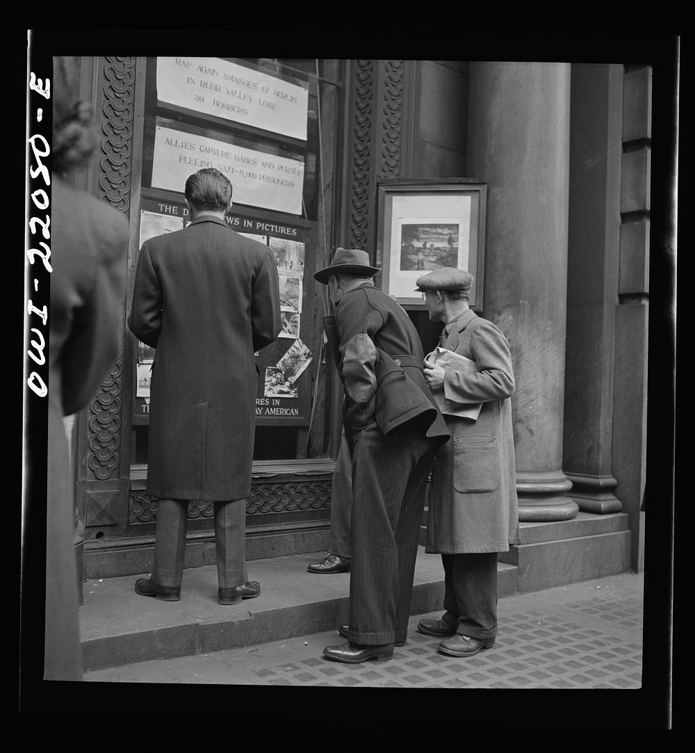 Baltimore, Maryland. Reading news bulletins and looking at the news pictures outside the Baltimore News building. Sourced…