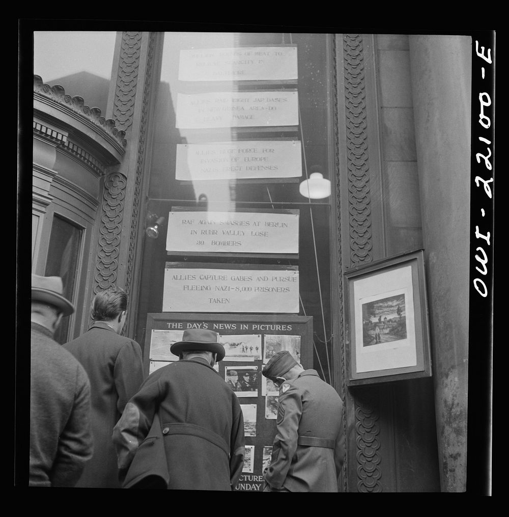 Baltimore, Maryland. Reading news bulletins and looking at the news pictures outside the Baltimore News building. Sourced…