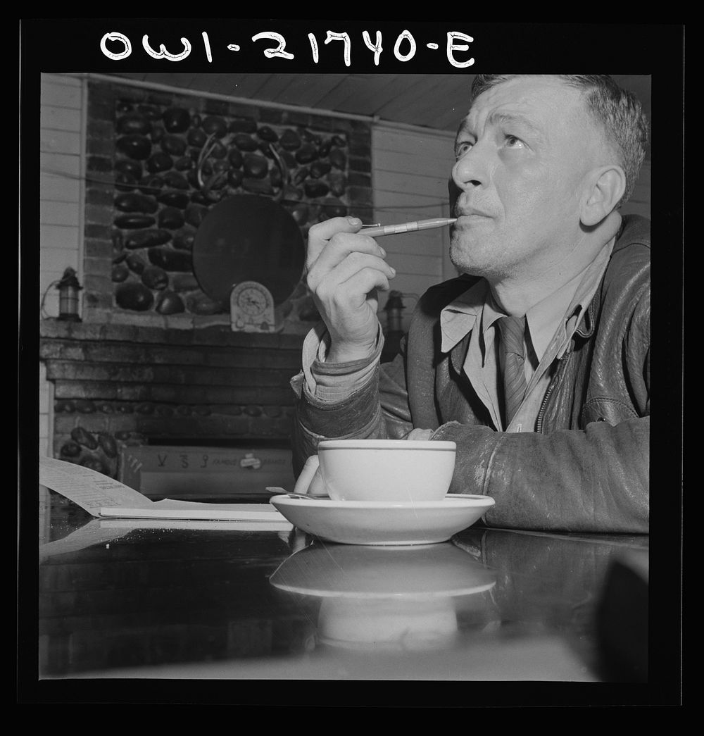 Pearlington, Mississippi. James Hall, truck driver, stopping for a cup of coffee and working on his log. Sourced from the…