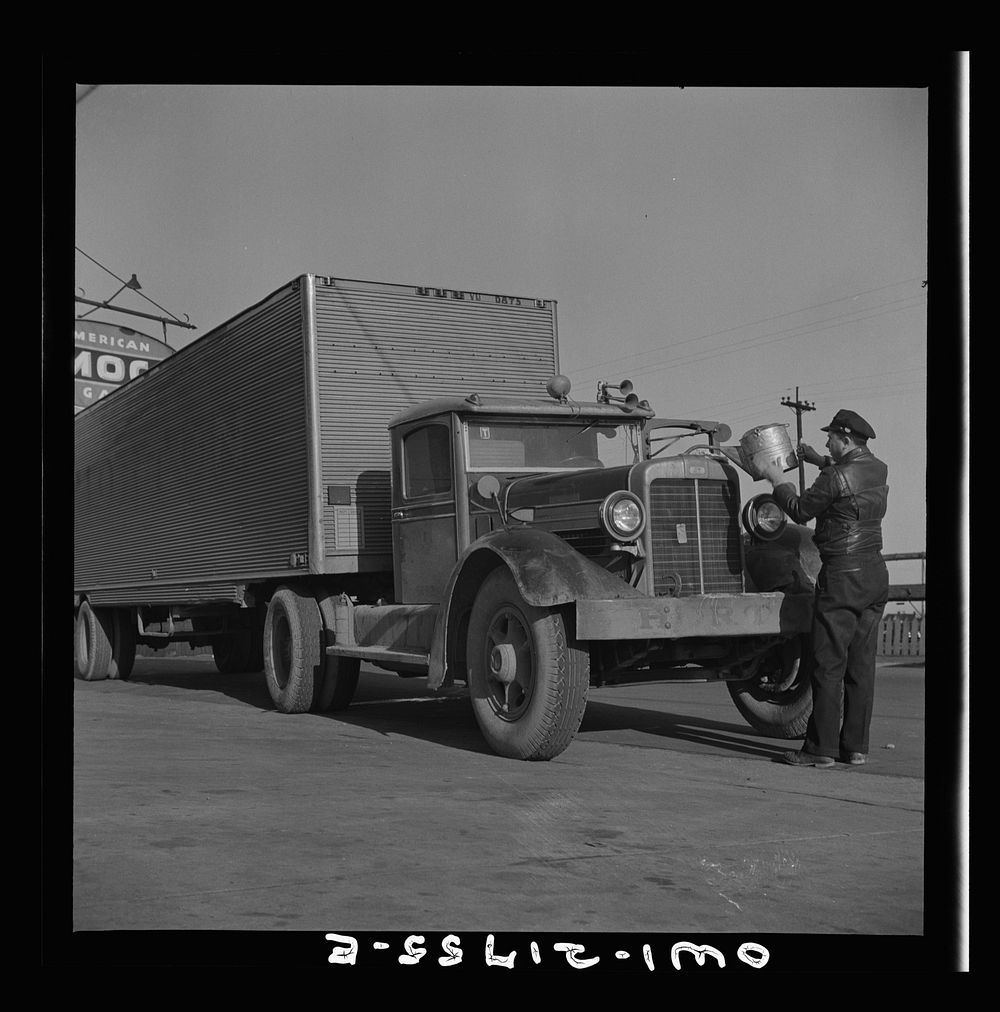 [Untitled photo, possibly related to: Melvin Cash, truck driver, putting water in his radiator along U.S. Highway 29 in…