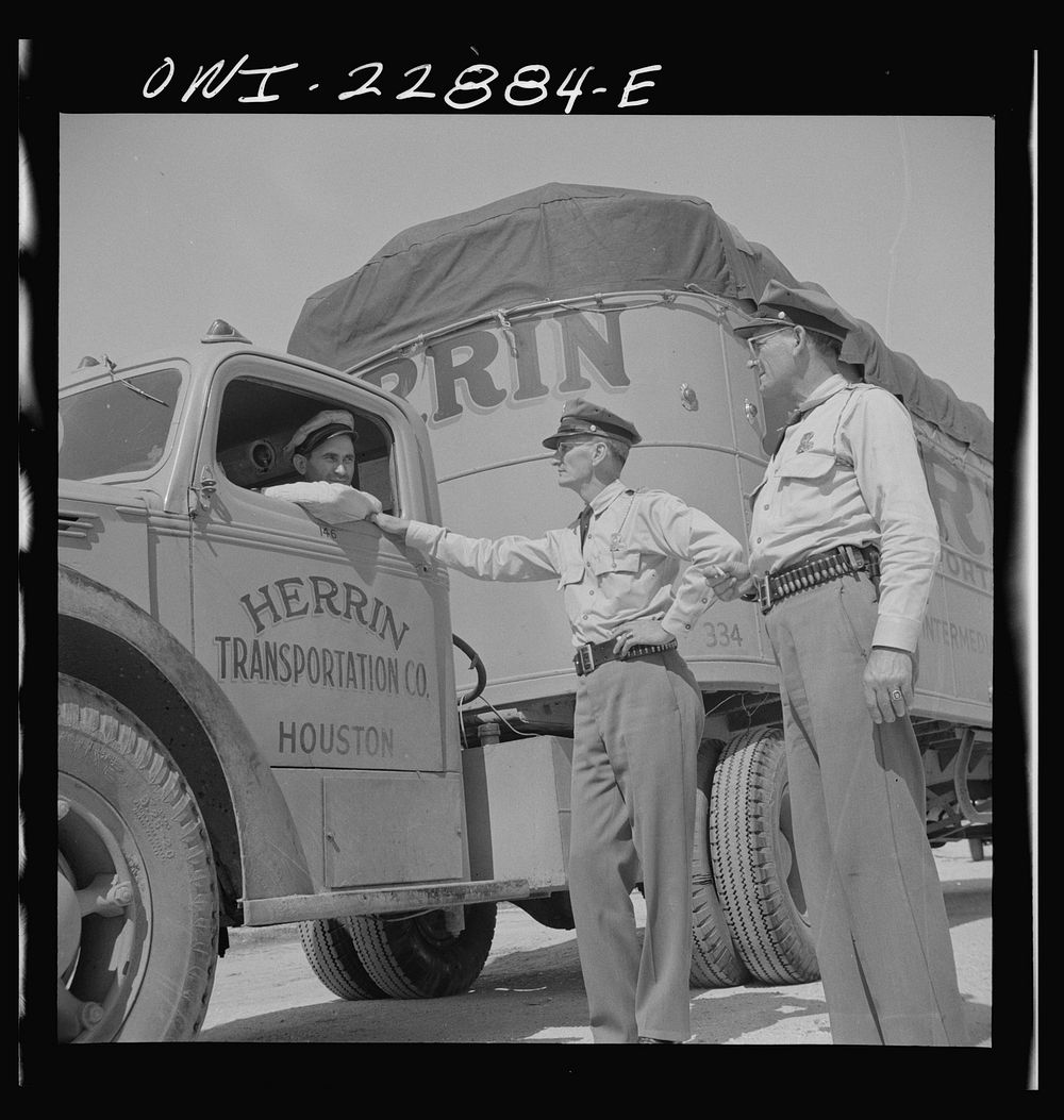 Franklin, Louisiana. State highway patrolmen talking with Jean Broussard, a Cajun truck driver. Sourced from the Library of…