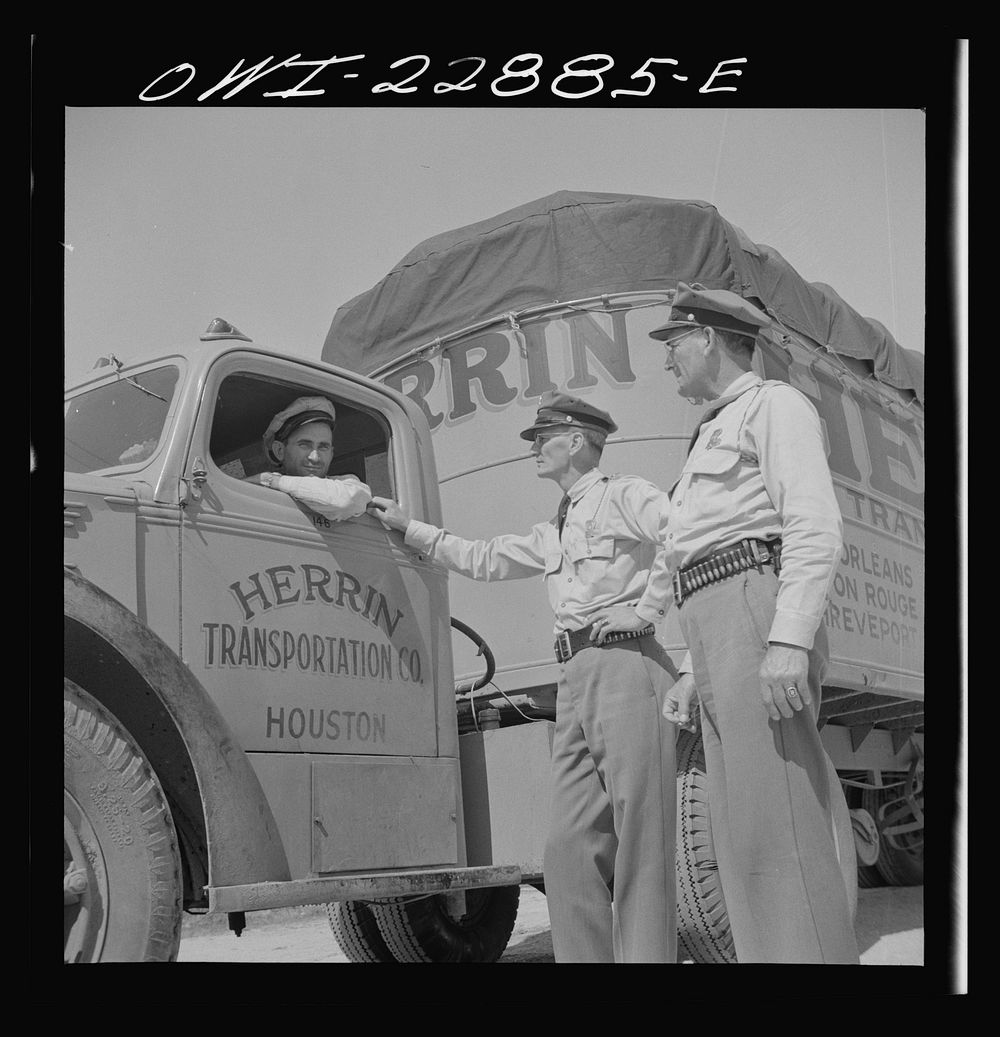 [Untitled photo, possibly related to: Franklin, Louisiana. State highway patrolmen talking with Jean Broussard, a Cajun…