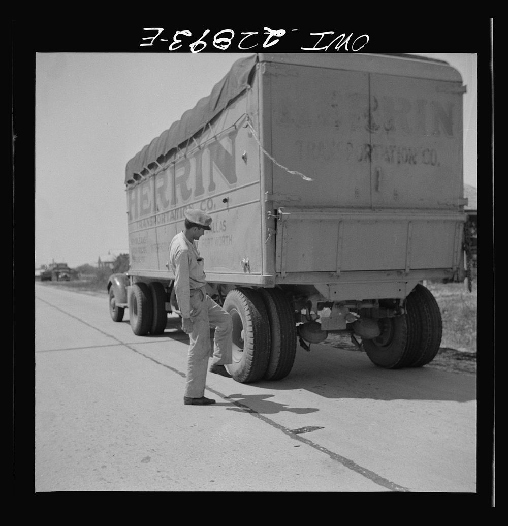 Jean Broussard checking tires on U.S. Highway 90 enroute to Lafayette, Louisiana. Sourced from the Library of Congress.