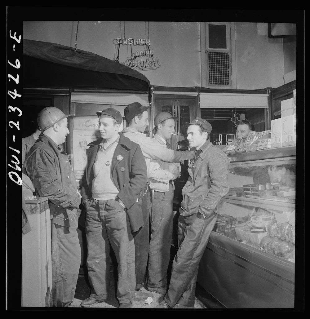 Baltimore, Maryland. Third shift defense workers waiting in a combination delicatessen and restaurant to be picked up by…