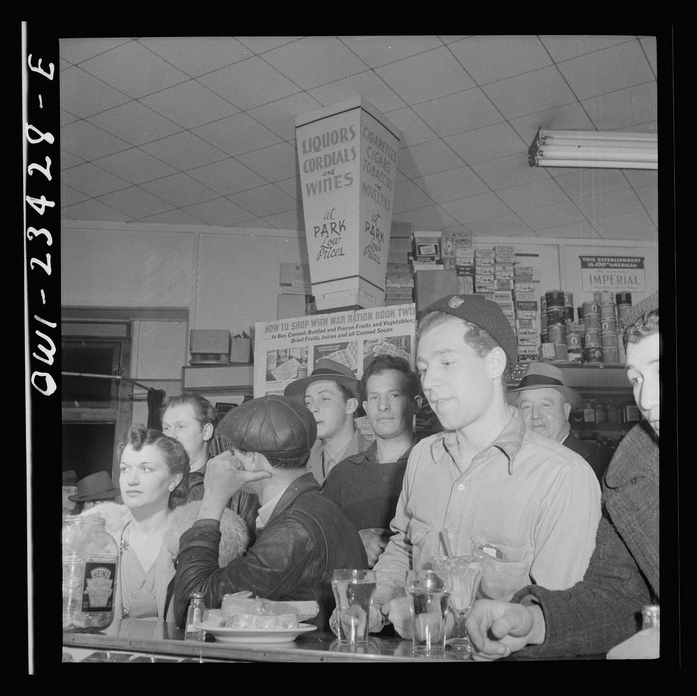 Baltimore, Maryland. Third shift defense workers getting a snack at the drugstore on the corner where their car pool will…