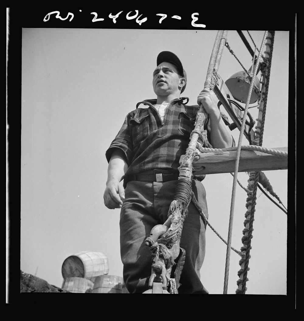 New York, New York. Gloucester fisherman standing in the rigging of a New England fishing boat. Sourced from the Library of…