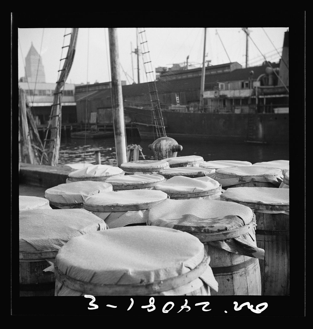 New York, New York. Barrels of fish on the docks at the Fulton fish market ready to be shipped to retailers. Sourced from…