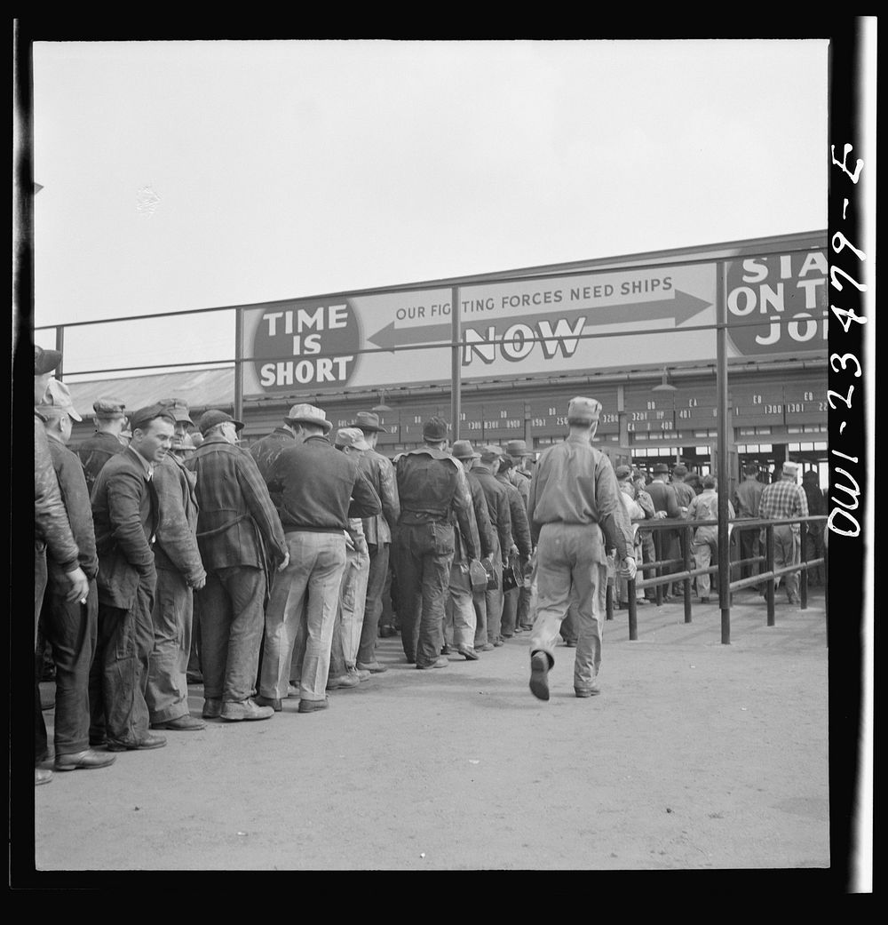 Bethlehem-Fairfield shipyards, Baltimore, Maryland. Lining up before time clock at the changing of the shifts. Sourced from…