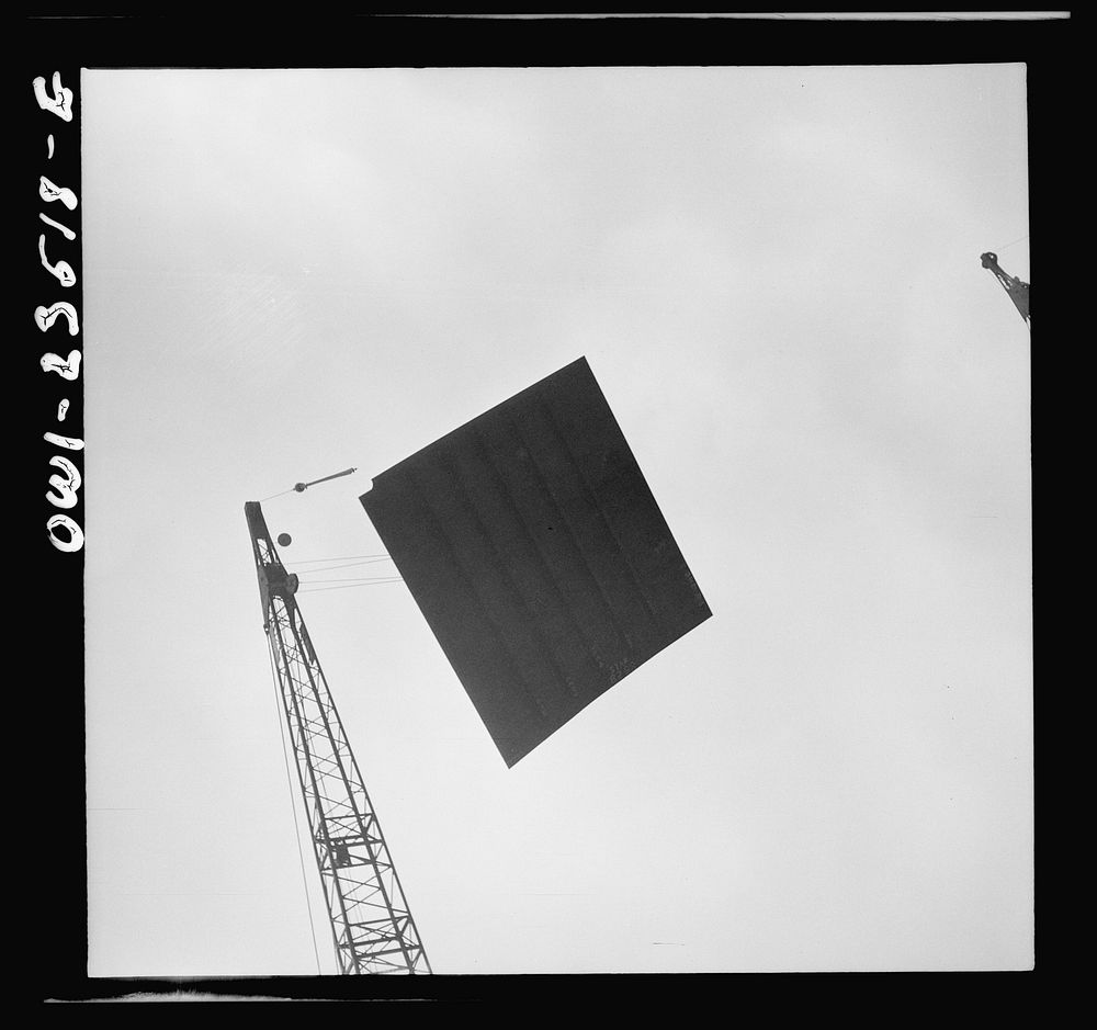 Bethlehem-Fairfield shipyards, Baltimore, Maryland. Deck section being lowered onto a ship. Sourced from the Library of…