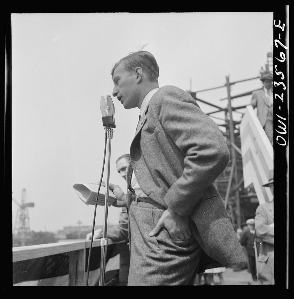Bethlehem-Fairfield shipyards, Baltimore, Maryland. Guest speaker, a merchant seaman, at a launching ceremony. Sourced from…