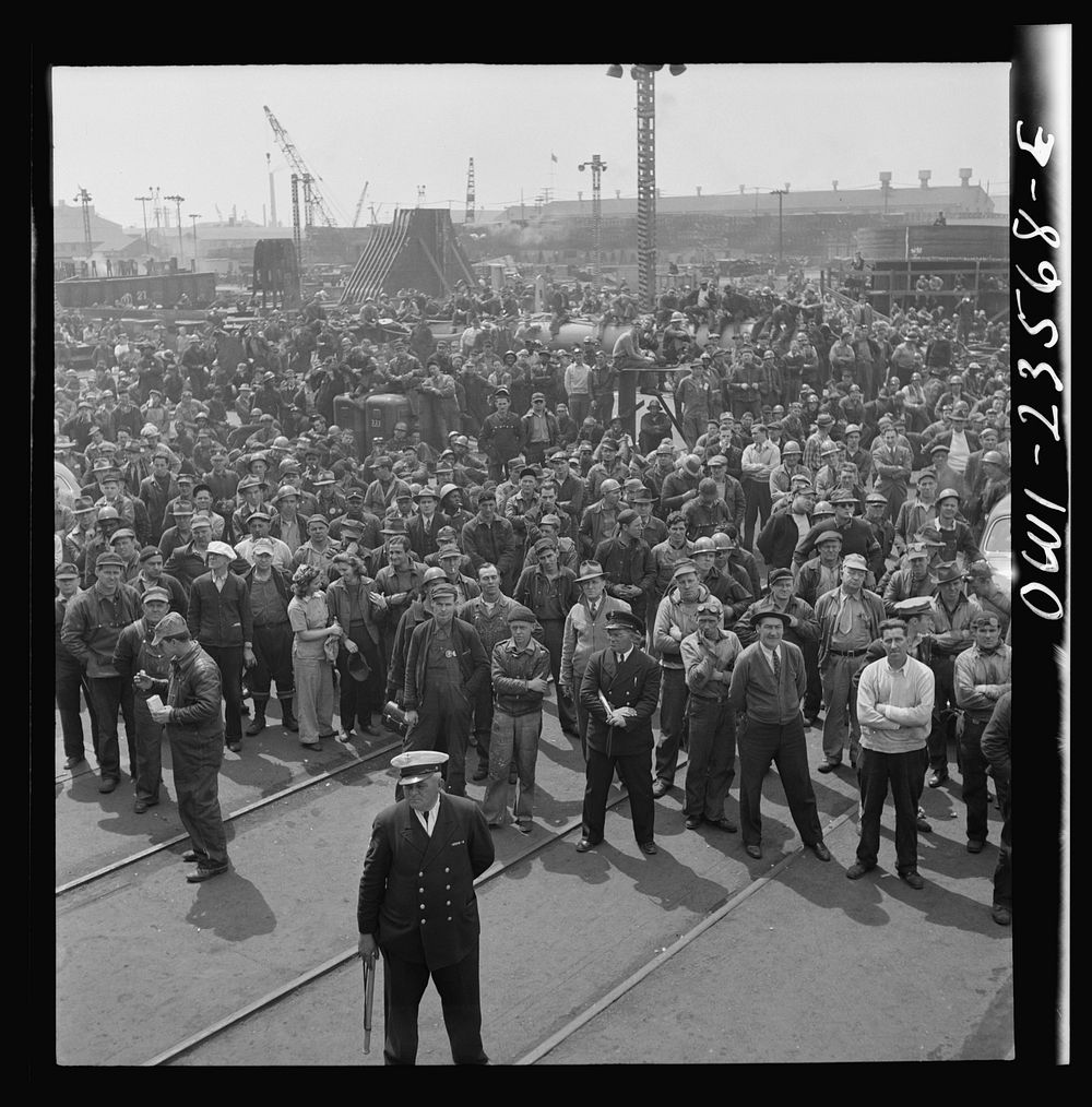 Bethlehem-Fairfield shipyards, Baltimore, Maryland. Shipyard workers attending a launching ceremony. Sourced from the…