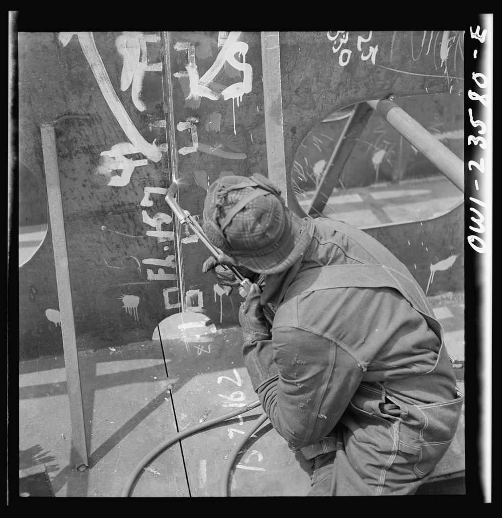 Bethlehem-Fairfield shipyards, Baltimore, Maryland. Burner working on an inner bottom unit. Sourced from the Library of…