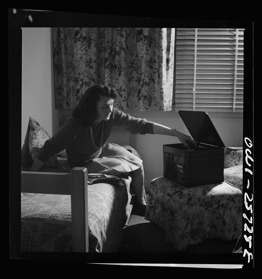 Arlington, Virginia. A girl in her room playing a phonograph at Arlington Farms, a residence for women who work in the…
