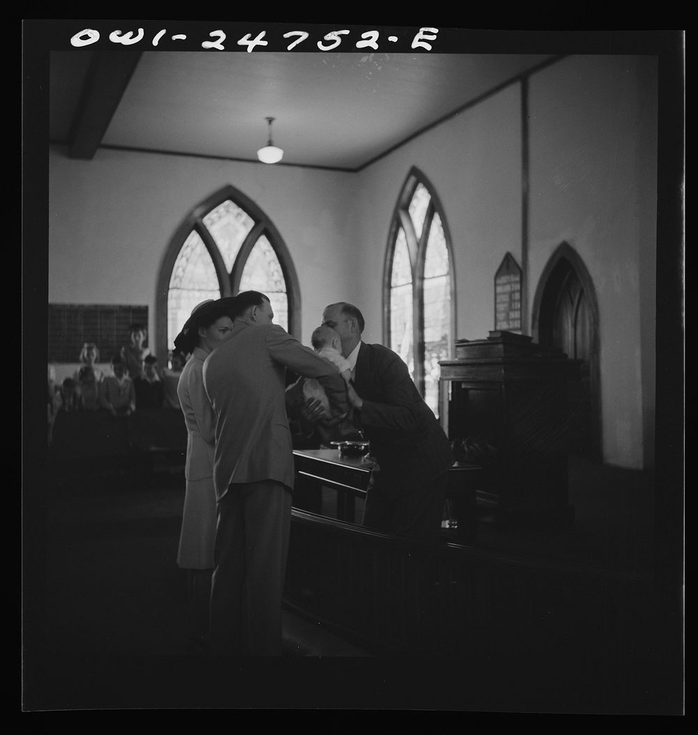 San Augustine, Texas. Reverend Dubberly returning an infant to its parents after the baptismal ceremony. Sourced from the…