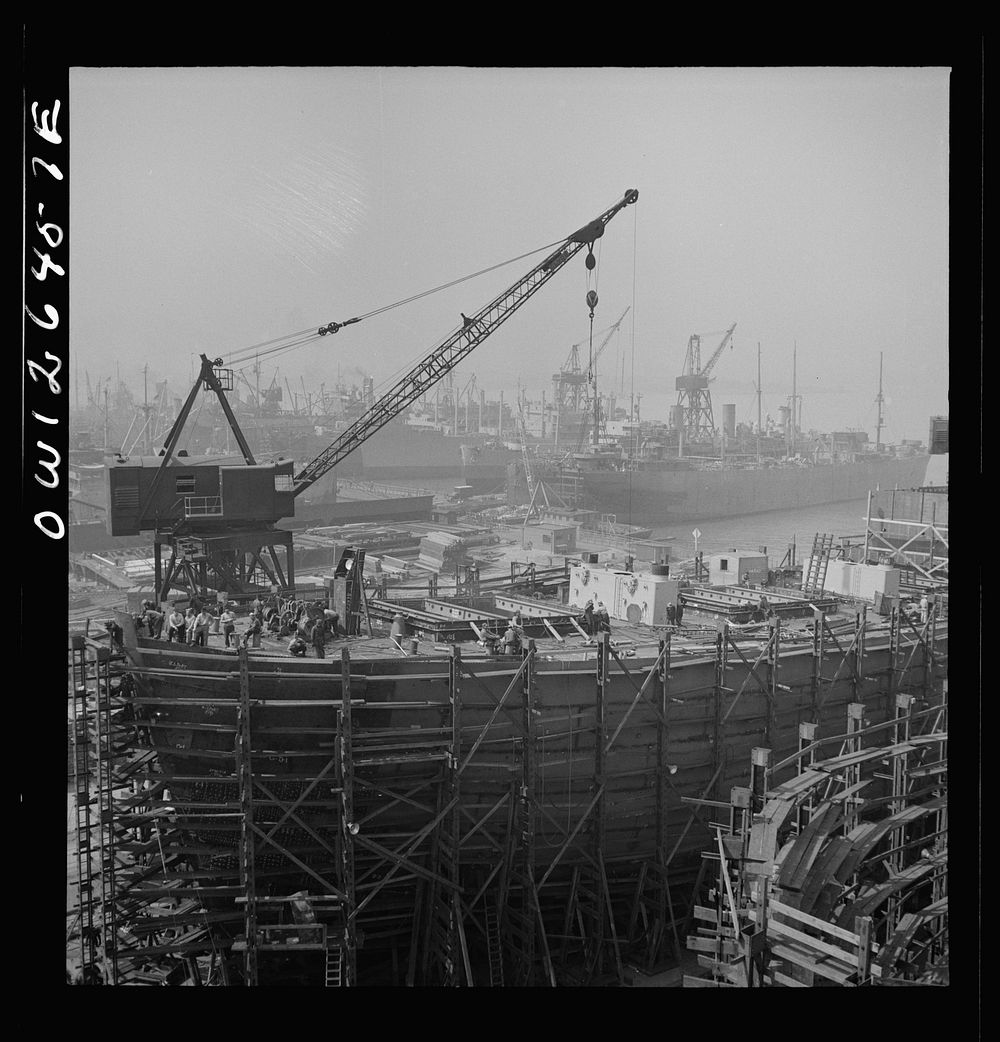 [Untitled photo, possibly related to: Bethlehem-Fairfield shipyards, Baltimore, Maryland. A shipyard with a crane]. Sourced…