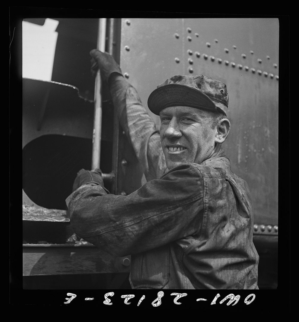 An American soldier engineer climbing into the cab of his train. An engineer in private life, he is happy at the chance to…