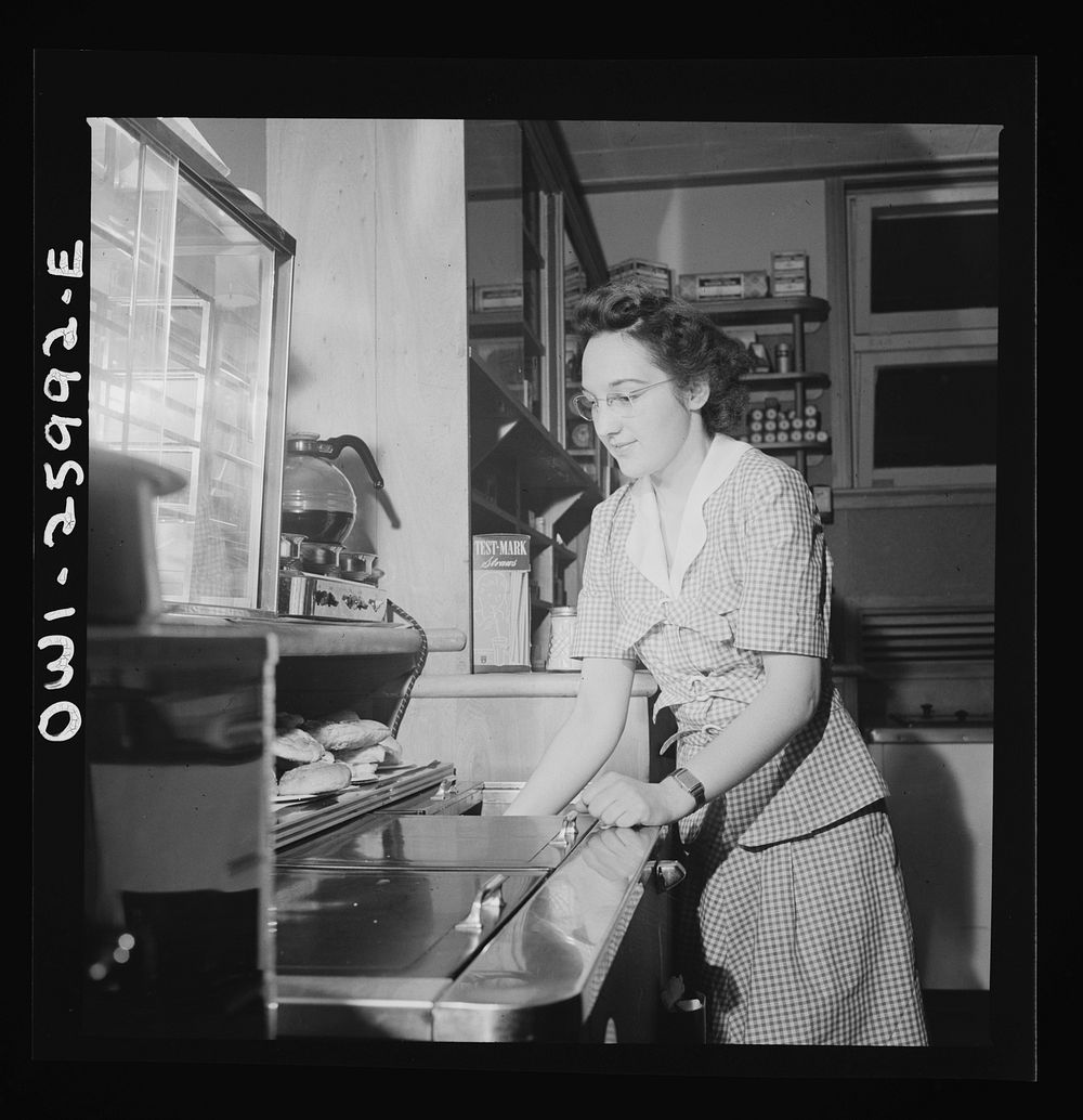 Arlington, Virginia. Girl getting food in the service shop at Idaho Hall, Arlington Farms, a residence for women who work in…