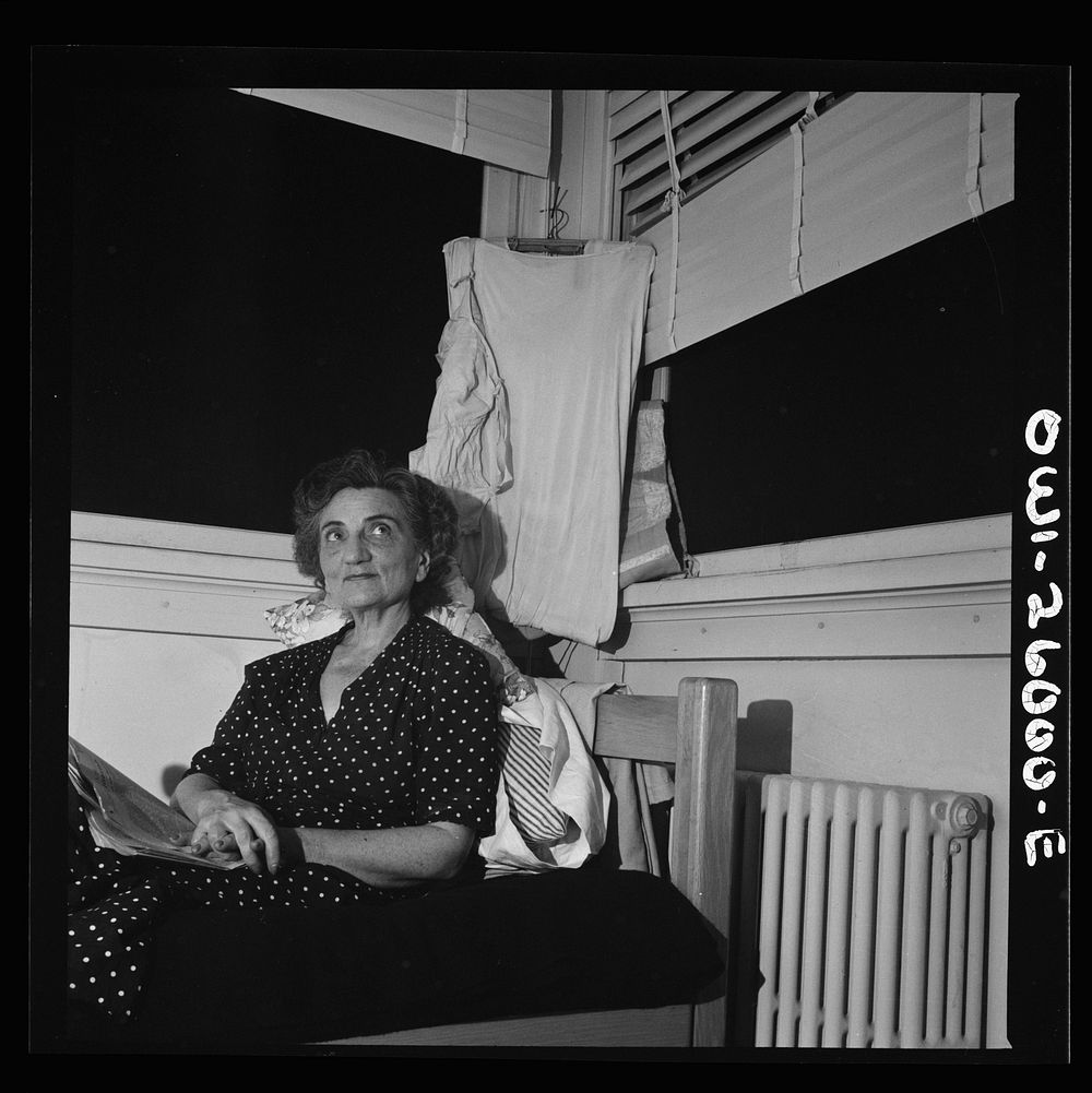 [Untitled photo, possibly related to: Arlington, Virginia. An older resident reading the paper and listening to the radio in…
