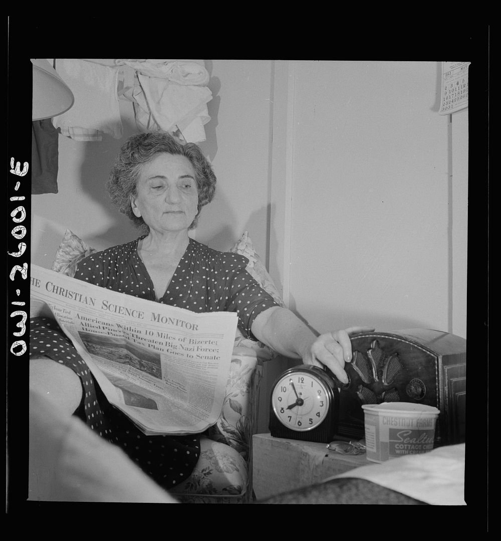 Arlington, Virginia. An older resident reading the paper and listening to the radio in her room at Idaho Hall, Arlington…