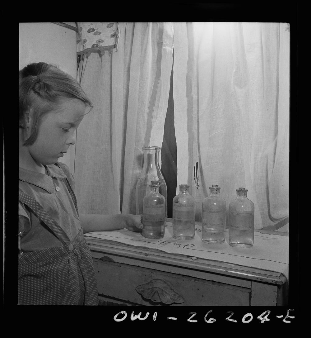 Buffalo, New York. Patsy Grimm, age six, removing the bottles from the kitchen table. Her mother, a twenty-six year old…